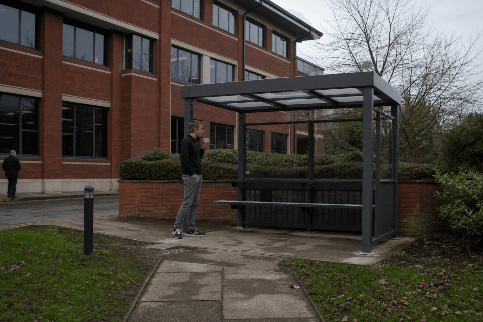 Aluminium smoking shelter outside a UK office building on an overcast day